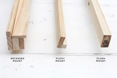 three pieces of wood sitting next to each other on a white surface with words below them