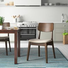 two chairs sitting at a table in front of a stove top oven and countertop