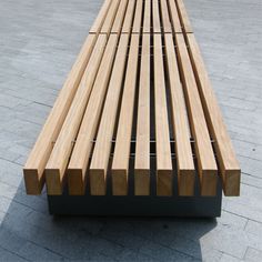 a wooden bench sitting on top of a cement ground