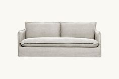 a gray couch with two pillows on it's back and the seat upholstered