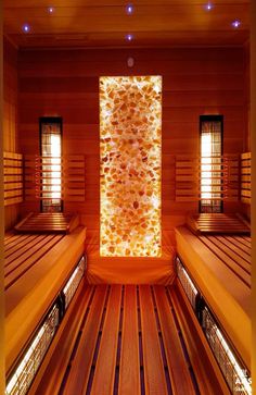 the inside of a sauna with wooden benches and lights on it's sides