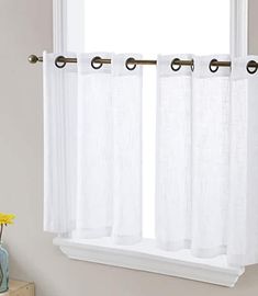 a white curtain hanging on the side of a window