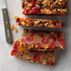 three pieces of fruit and nut bar next to a knife