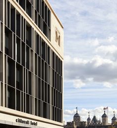 a tall building sitting on the side of a road next to a bridge and buildings