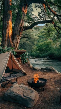 there is a campfire next to a tent in the woods