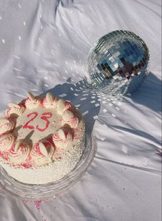 a cake with the number twenty five on it and a disco ball in the background