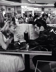 a man and woman sitting at a table in front of a book that says, why couldn't i be born into this era instead