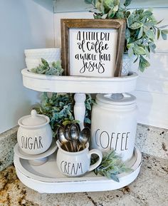 a kitchen shelf with coffee mugs, sugar and cream dishes on it next to a potted plant