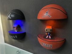 two basketballs are mounted to the wall and one has a bobble head on it