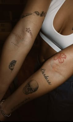 two women with tattoos on their arms, one is holding the other's arm