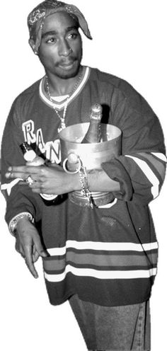 a black and white photo of a man holding a bowl in one hand and a cup in the other