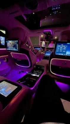 the interior of a car with purple lighting and touchscreens on it's dash boards