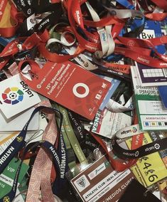 a pile of lanyards that are all different colors and sizes with ribbons around them