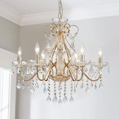 a chandelier hanging from the ceiling in a room with white walls and windows