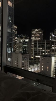 a view of the city at night from a hotel room window