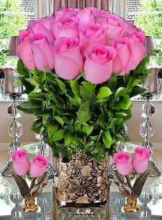 a vase filled with pink roses on top of a table