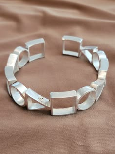 The bracelet is geometric style with .25 inch circles, squares, and triangles.  Solid 925 silver filled. Silver Cuff Bracelet For Women, Cool Silver Bracelets, Geometric Sterling Silver Jewelry, Handmade Silver Geometric Jewelry, Elegant Adjustable Geometric Bracelet, Geometric Silver Jewellery, Geometric Accessories, Contemporary Bracelets, Contemporary Jewellery Designers