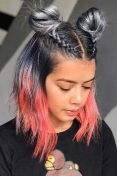 a girl with pink and black hair is looking at her cell phone while wearing a bear t - shirt