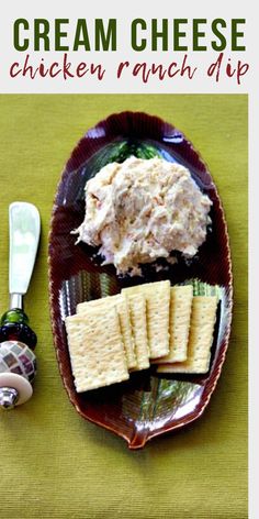 a plate with crackers and cheese on it next to a bottle of cream cheese