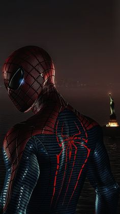 the amazing spider - man is standing in front of a cityscape at night