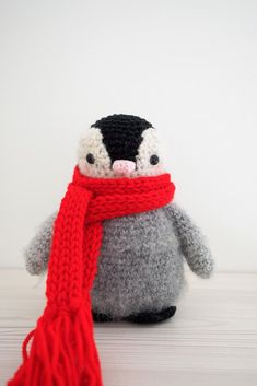 a stuffed penguin with a red scarf around it's neck and the caption baby penguin toy free crochet pattern