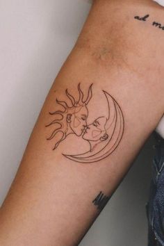 a woman's arm with a sun and moon tattoo on it