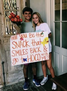 a man and woman standing next to each other holding a sign that says will you be the snack that smiles back & 90th hoo