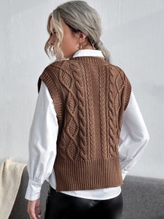 a woman wearing a brown cable knit vest