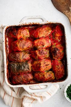 a casserole dish filled with meat and vegetables on top of a white table