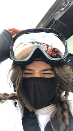 a woman wearing ski goggles and a black mask