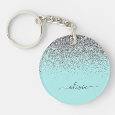 a blue and silver glitter keychain with the word alive on it's side