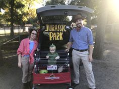 a man and woman standing next to a baby in a stroller