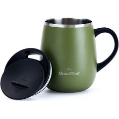 a green and black coffee mug next to the lid