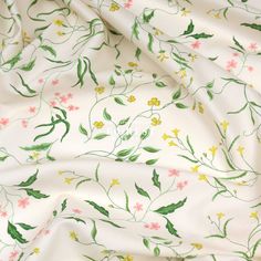 a white fabric with green and pink flowers on the bottom right corner, in full bloom