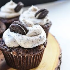 chocolate cupcakes with oreo cookies and cream frosting on a wood slice