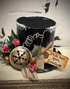 a black top hat decorated with christmas decorations and personalized name tag on the side