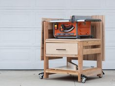 a workbench with a table sawing on it's wheels and drawers