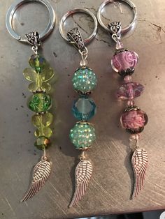 three key chains with charms attached to them