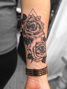 a woman's arm with a rose tattoo on it