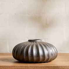 a silver vase sitting on top of a wooden table