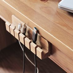 an electronic device is plugged into a charging station on a wooden table next to a laptop