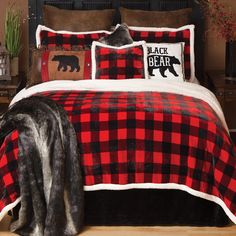 a bed with red and black buffalo plaid comforter, pillows and blankets on it