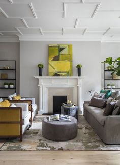 a living room filled with furniture and a fire place in front of a painting on the wall