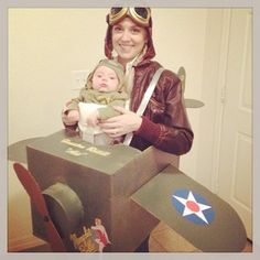 a woman is holding a baby in an airplane costume