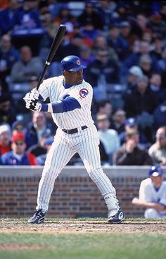 a baseball player holding a bat on top of a field in front of a crowd