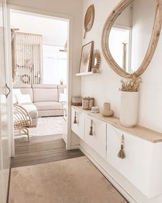 a living room filled with furniture and a large mirror on the wall next to a doorway