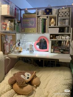 a stuffed animal sitting on top of a bed next to a book shelf filled with books