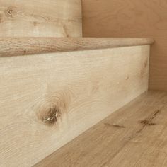 the bottom part of a wooden shelf with wood flooring