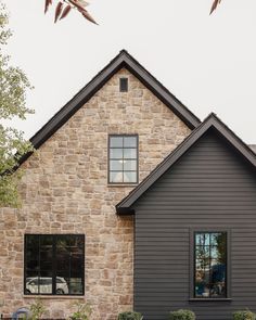 a gray house with black shutters and windows