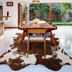 a dining room with a cow hide rug on the floor